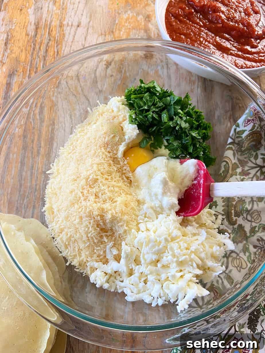 Three Cheese Manicotti Crepes Recipe 4 Ricotta, parmesan, mozzarella cheese, fresh parsley and one egg in glass mixing bowl.
