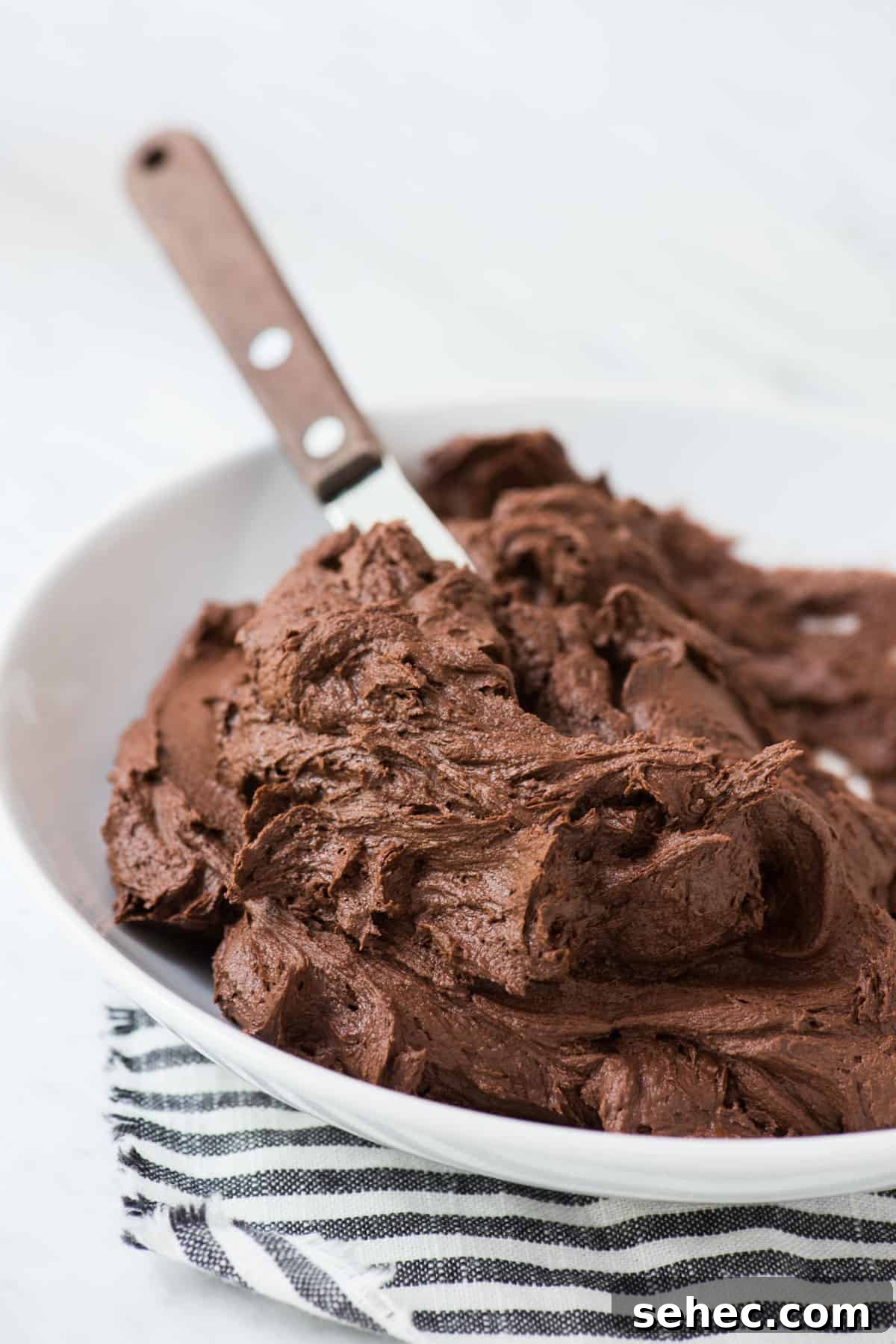 Chocolate Frosting Recipe for Cakes and Cupcakes 3 chocolate frosting in white bowl with striped towel