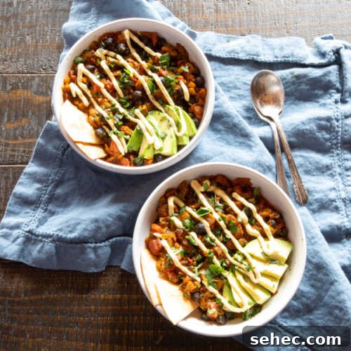 January Vegetarian Meal Plan Week 4 7 Two bowls of chana masala using black chickpeas, topped with slices of avocado and a squeeze of vegan sour cream.