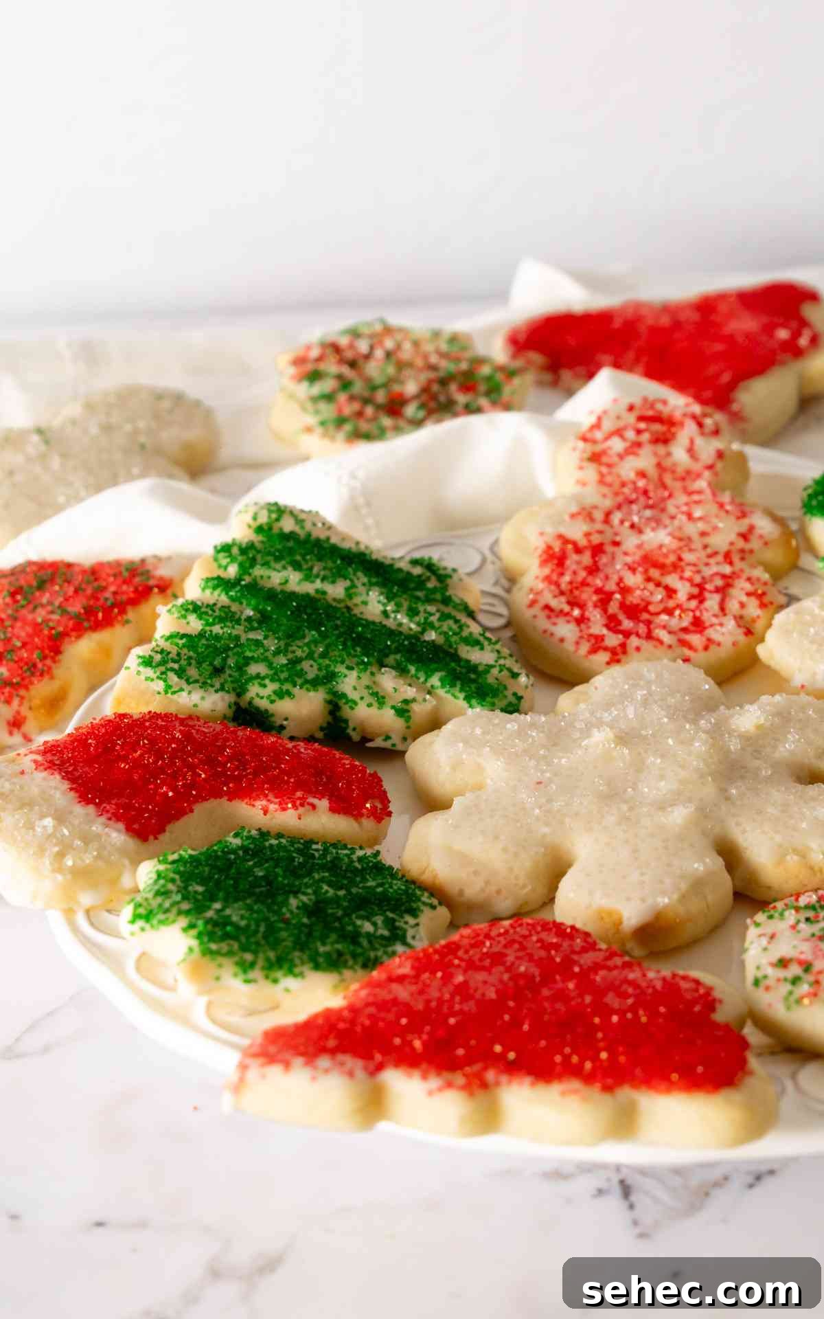 Soft Cream Cheese Sugar Cookies From Scratch 3 Cream cheese sugar cookies for Christmas on white decorative plate.