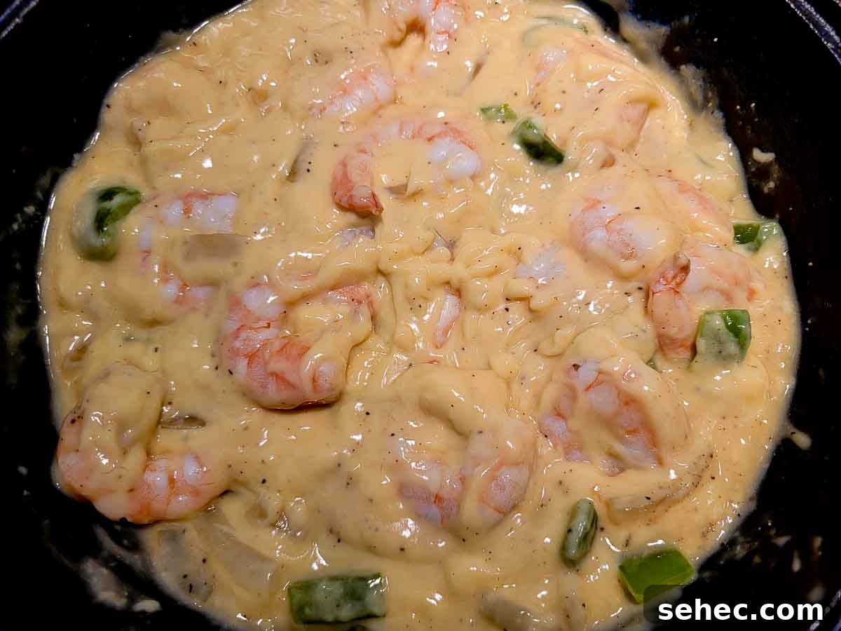 Creamy Shrimp and Rice Skillet 5 shrimp, soup, water, salt, black pepper, green pepper and onion frying in a skillet.