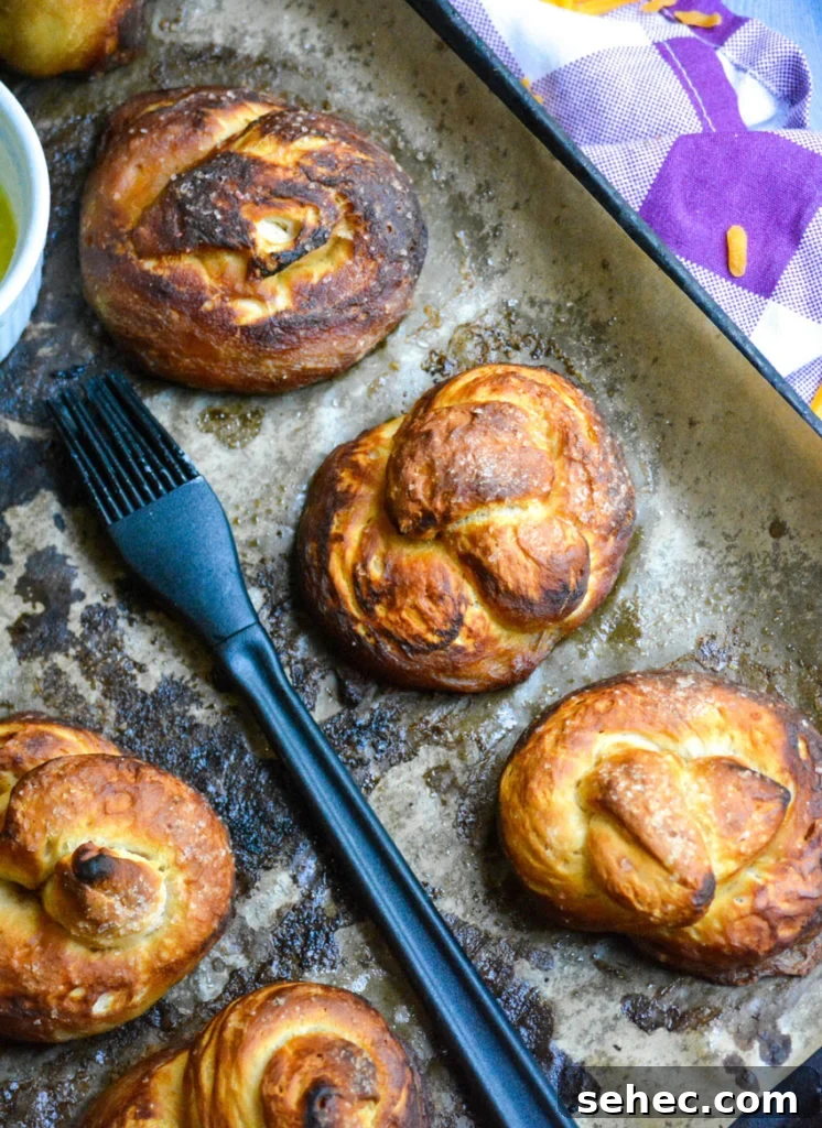 Soft Pretzels Made with Canned Biscuits 4 baked buttered canned biscuit pretzels shown on a sheet of brown parchment paper