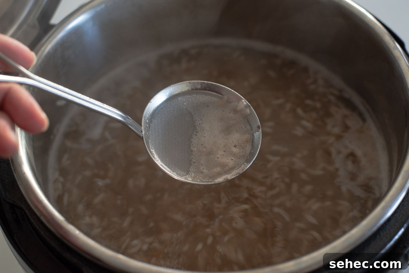 Homemade Sikhye Korean Sweet Rice Drink Recipe 14 Skimming foam from sikhye with a fine strainer