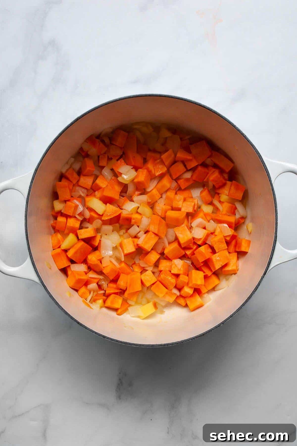 Creamy Pumpkin Sweet Potato Soup Recipe 4 Sautéing chopped sweet potato, onion, and apple in a Dutch oven to start pumpkin sweet potato soup.