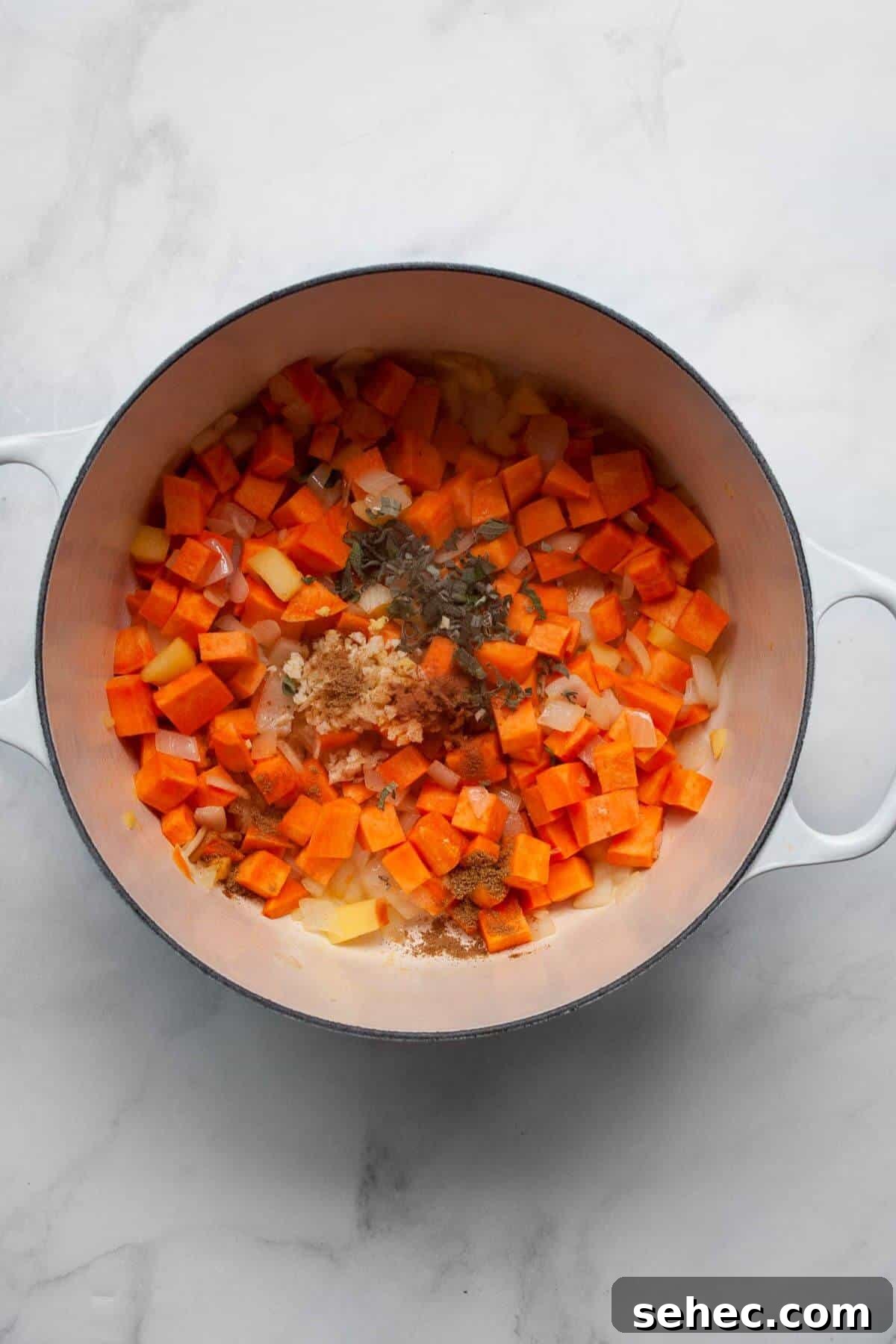 Creamy Pumpkin Sweet Potato Soup Recipe 5 Adding fresh ginger, sage, and spices to the sautéing onions, apple, and sweet potato cubes.