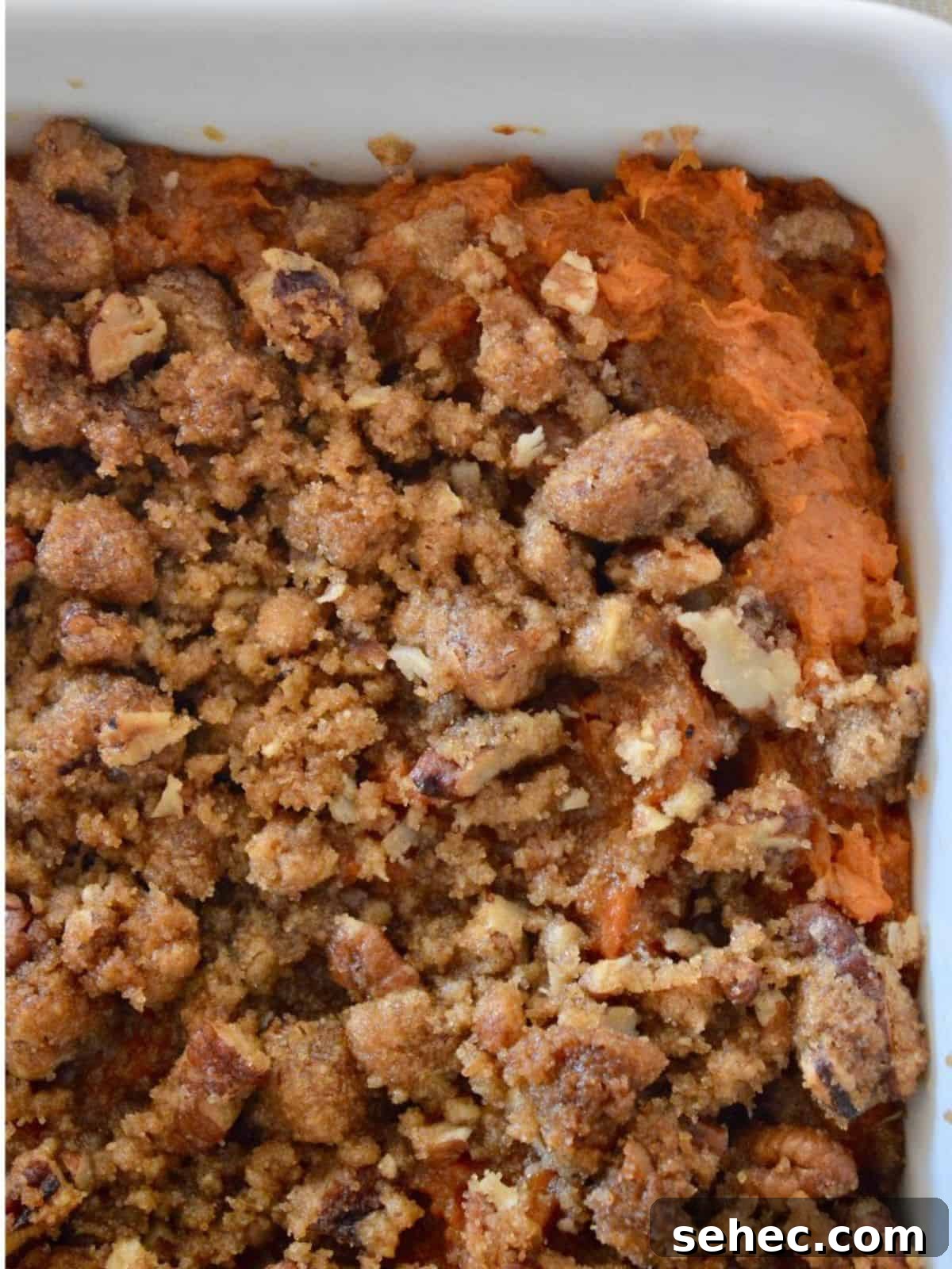 Eggless Sweet Potato Casserole with Pecan Streusel 7 Sweet Potato Casserole with pecan streusel topping in a white serving dish.