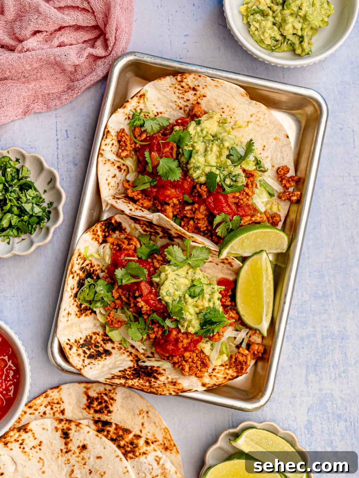 Ground Chicken Tacos with Juicy Mexican Seasoning 2 Ground chicken tacos topped with salsa and guacamole.