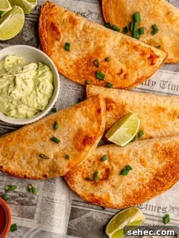Baked buffalo chicken tacos with a bowl of avocado yogurt sauce.