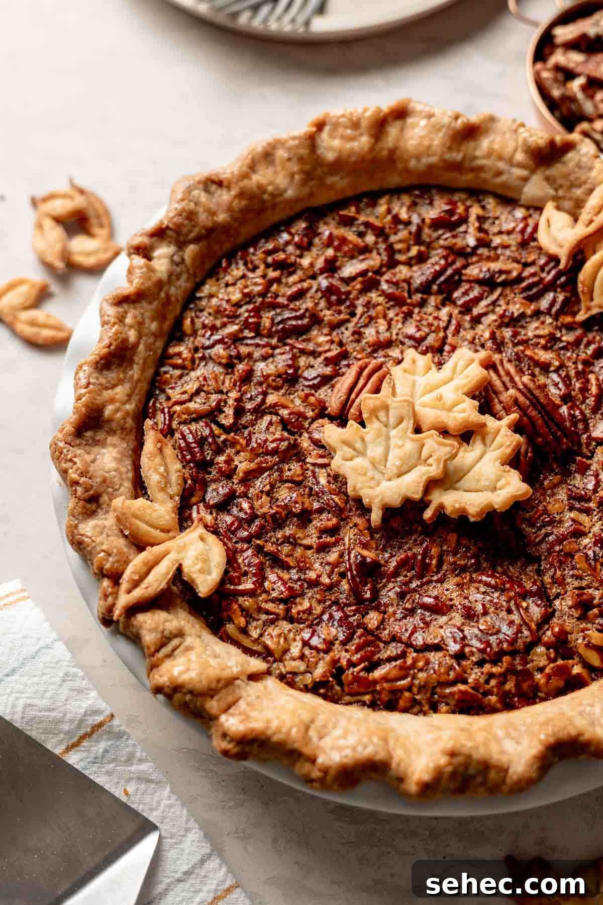 Gluten Free Pecan Pie Recipe with Classic Southern Flavor 4 Whole gluten free pecan pie in golden brown pie crust with leave cutouts as garnish.