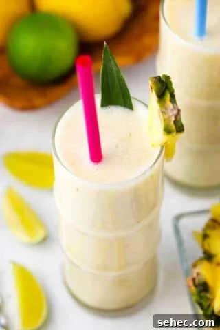 pineapple smoothie with lime wedges next to it