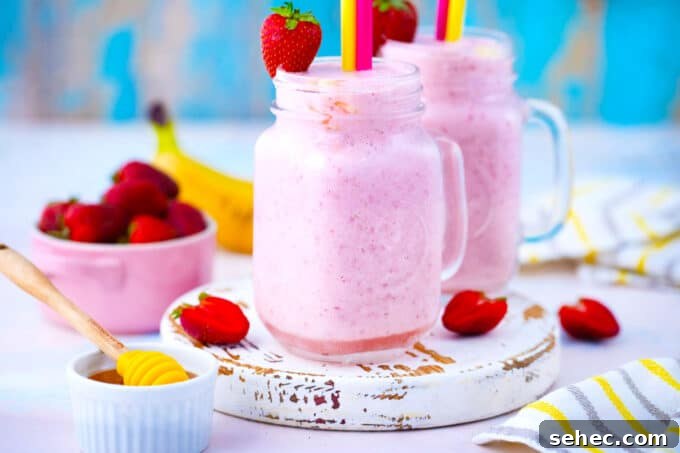 Creamy Strawberry Banana Smoothie Recipe 3 Strawberry banana smoothies garnished with fresh strawberries and banana slices.