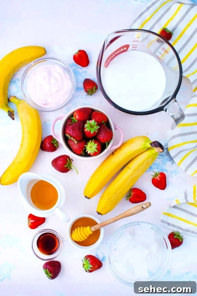 Creamy Strawberry Banana Smoothie Recipe 4 Strawberry banana smoothie ingredients in bowls on a table.
