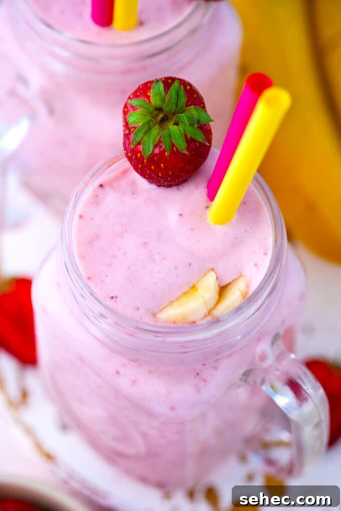 Creamy Strawberry Banana Smoothie Recipe 10 Overhead shot of creamy, pink strawberry banana smoothie, served with fresh strawberries.