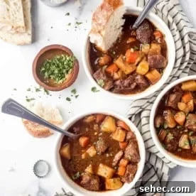 Slow Cooker Beef and Barley Stew Recipe 12 Three white bowls of Guinness stew on a white surface