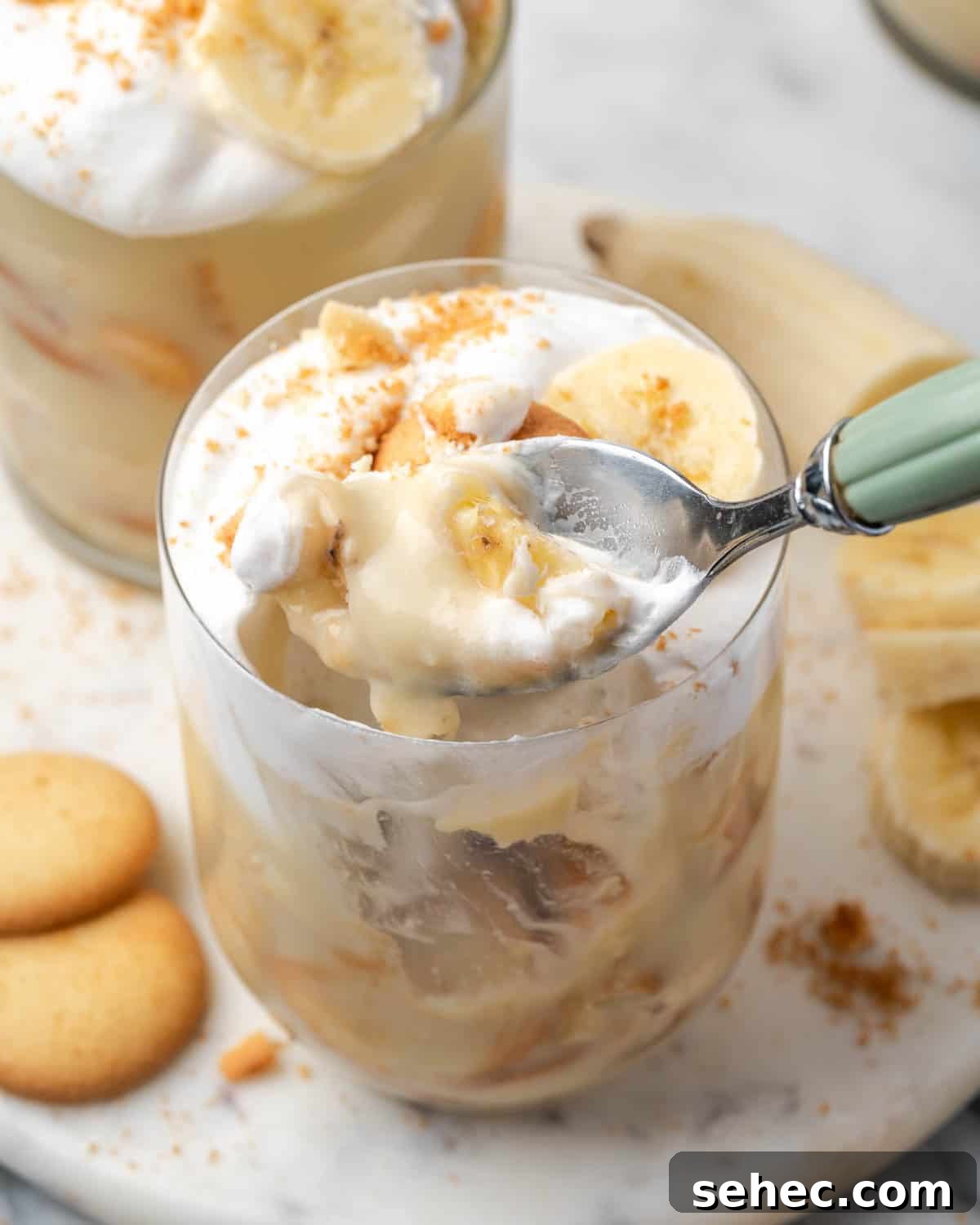 Homemade Banana Pudding Recipe From Scratch 11 A spoon scooping a bite of banana pudding from a serving glass.