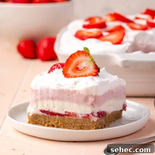 A slice of strawberry delight served on a white plate.