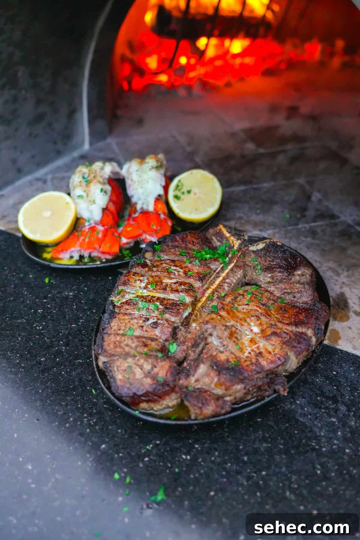 Peter Luger Surf and Turf Steak and Lobster Recipe 2 Close-up of Peter Luger surf and turf with lobster and steak in front of glowing embers.