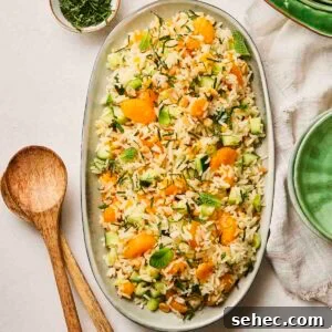 Rice Salad with Fresh Vegetables and Herbs 11 A platter with a rice salad on top, ready to serve out onto plates, with salad serves at the side.