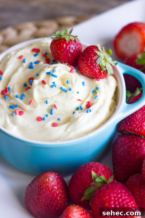 Creamy Vanilla Pudding Fruit Dip Recipe 3 Easy creamy vanilla pudding fruit dip in a bowl topped with sprinkles and fresh strawberries, surrounded by more fresh strawberries on a platter.