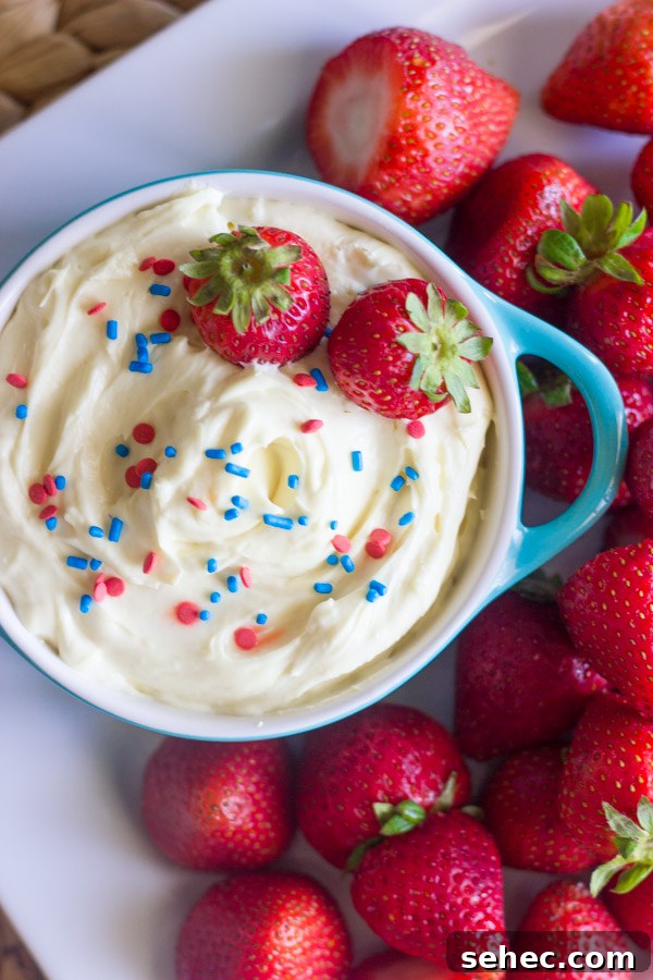 Creamy Vanilla Pudding Fruit Dip Recipe 4 Easy creamy vanilla pudding fruit dip in a bowl topped with sprinkles and fresh strawberries, surrounded by more fresh strawberries on a platter.