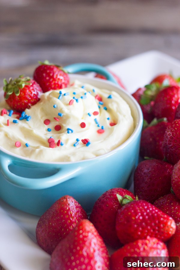 Creamy Vanilla Pudding Fruit Dip Recipe 6 Easy creamy vanilla pudding fruit dip in a bowl topped with sprinkles and fresh strawberries, surrounded by more fresh strawberries on a platter.