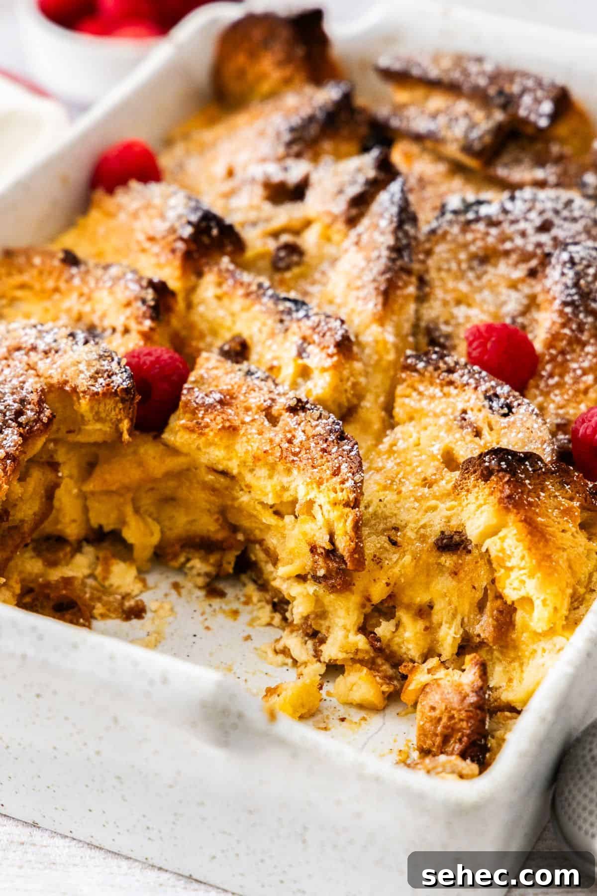 Panettone Bread and Butter Pudding Recipe 4 Large white rectangular dish of Panettone Bread and Butter Pudding, a serve having been removed.