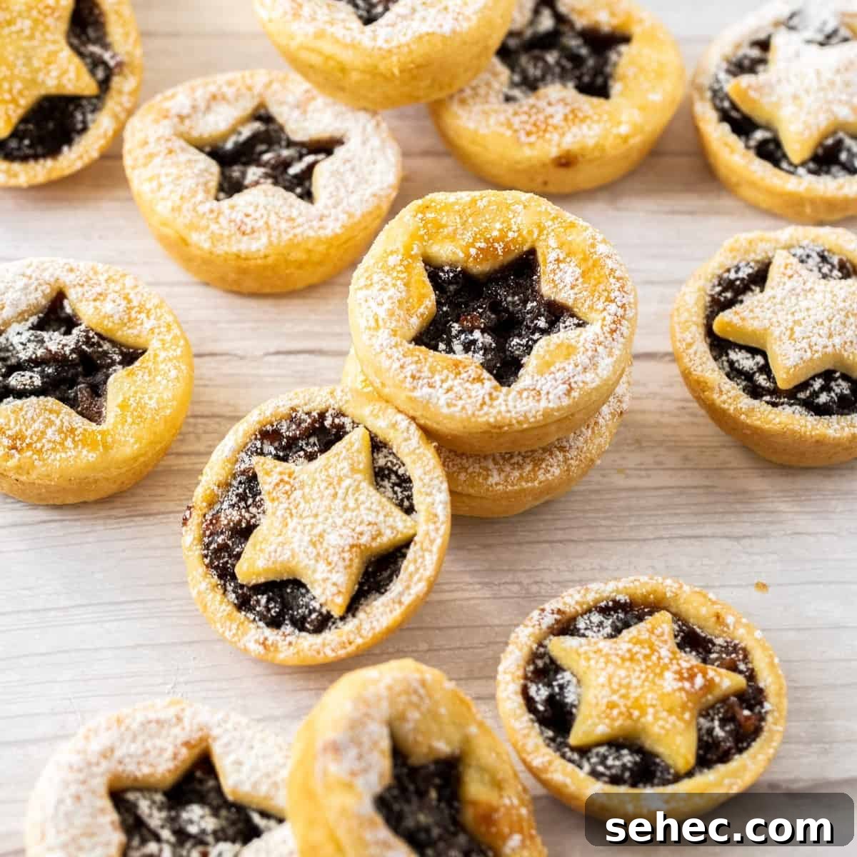 Mince pies dusted with icing sugar on a bench.