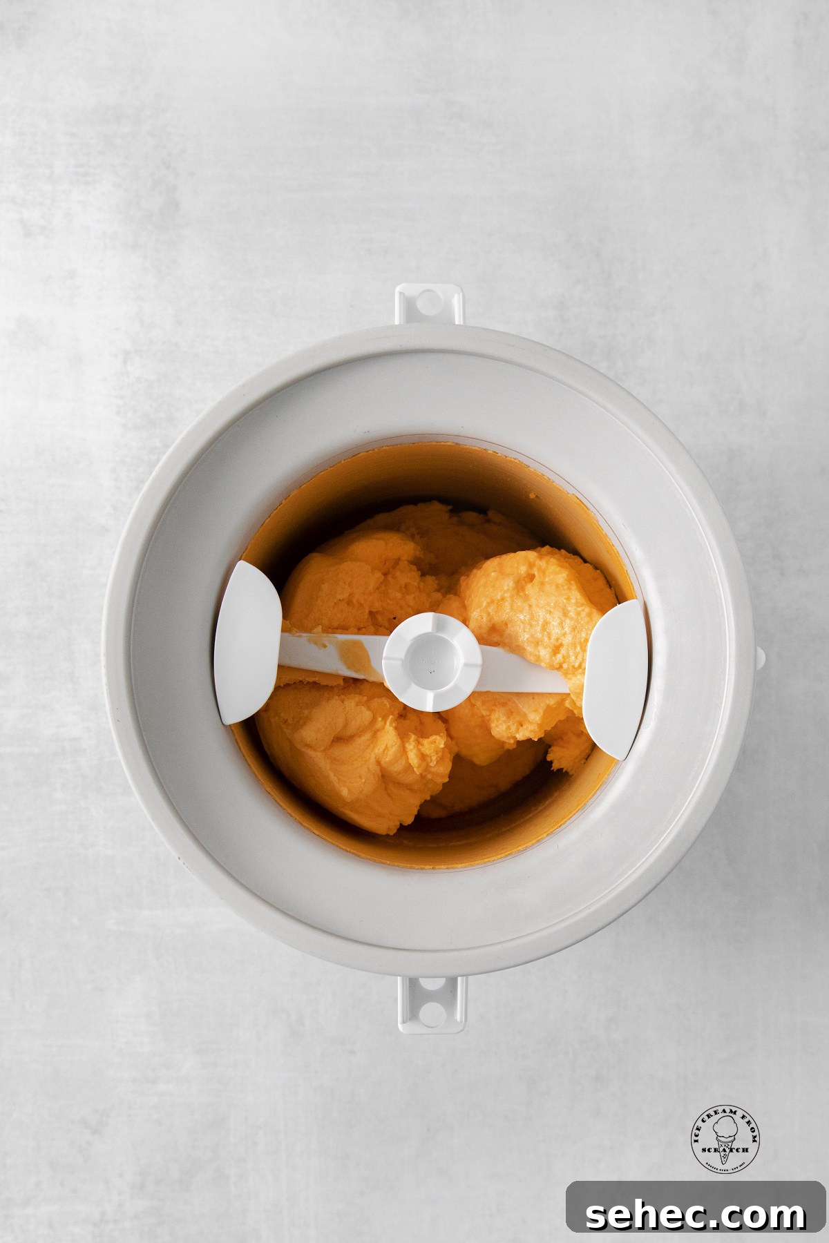 orange sherbet churning in an electric ice cream maker.
