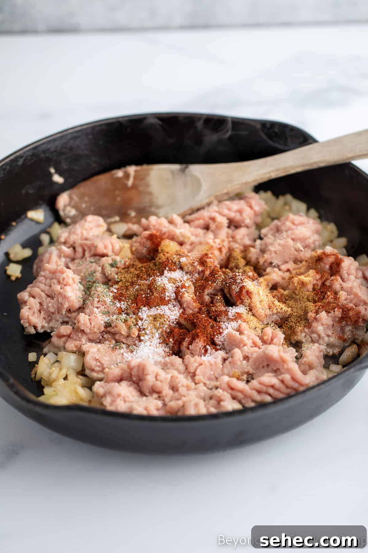 Ground Turkey Enchiladas Recipe 5 Seasoning sprinkled over raw burger.