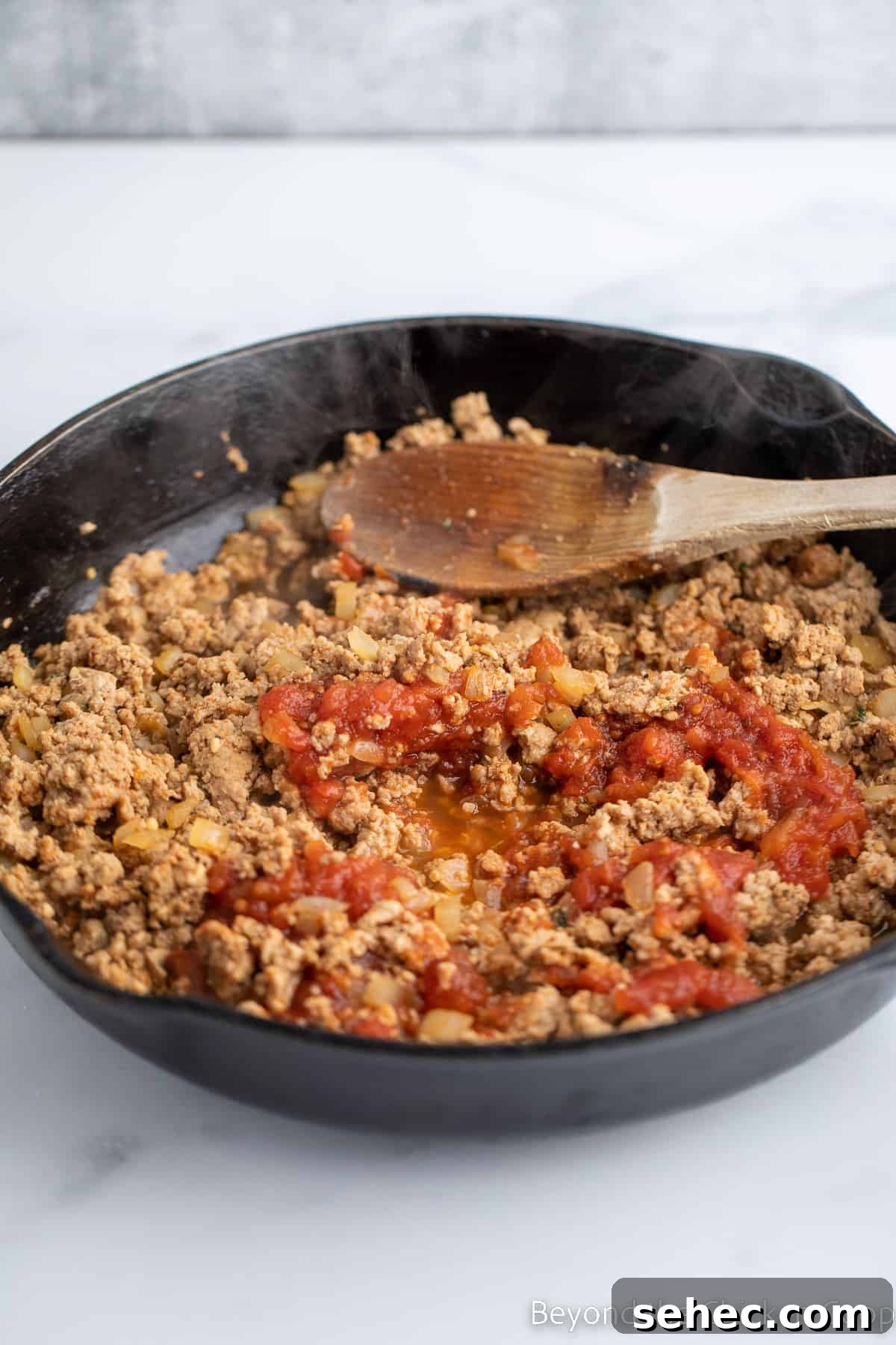 Ground Turkey Enchiladas Recipe 6 Tomato sauce added to cooked burger.