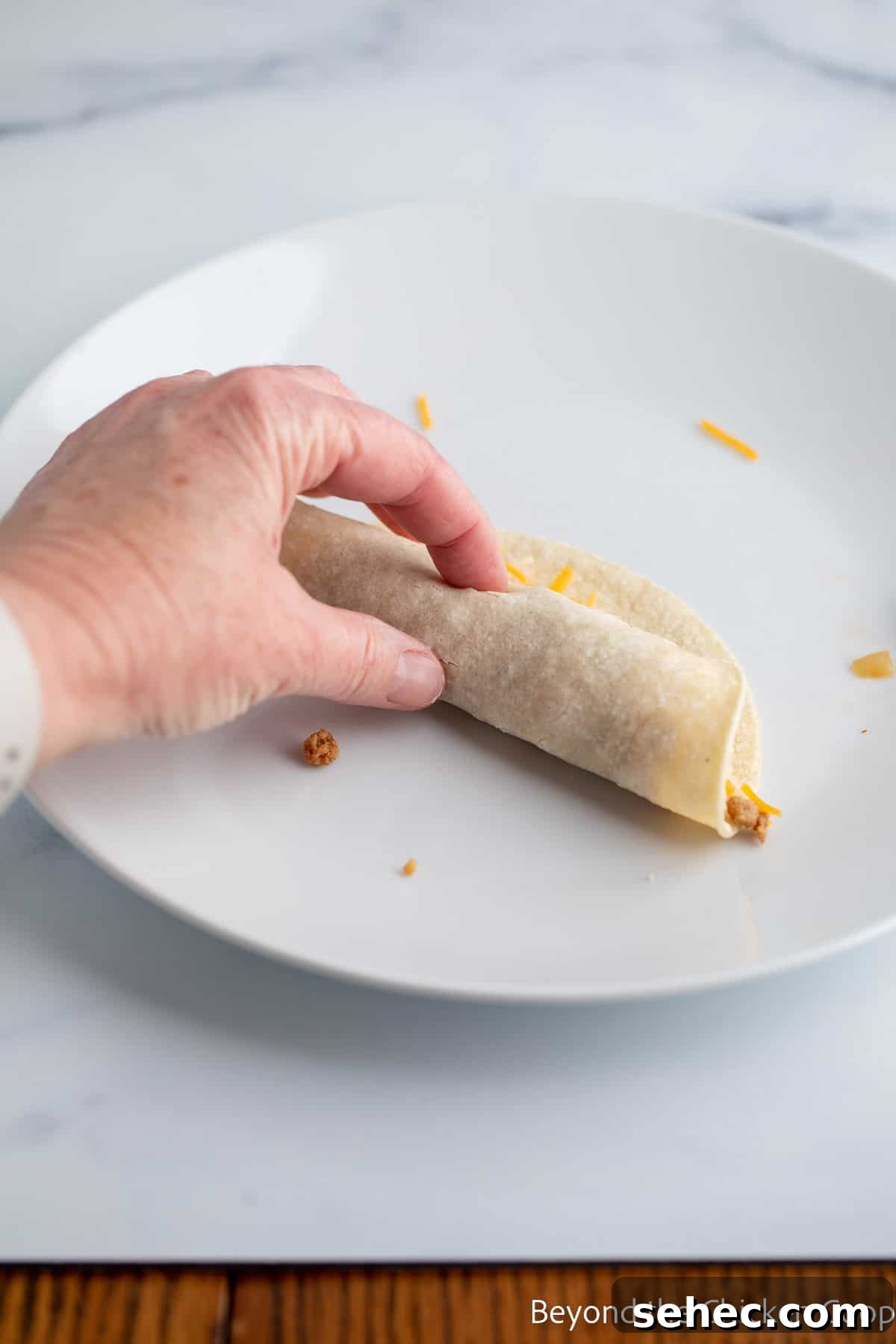 Ground Turkey Enchiladas Recipe 9 Rolling up a tortilla.