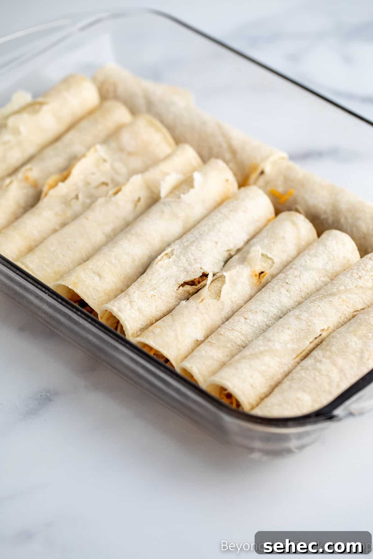 Ground Turkey Enchiladas Recipe 10 Rolled enchiladas in a baking dish.