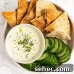 Creamy Whipped Feta Dip with Honey and Herbs 6 a top down view of whipped feta dip with pita and cucumber