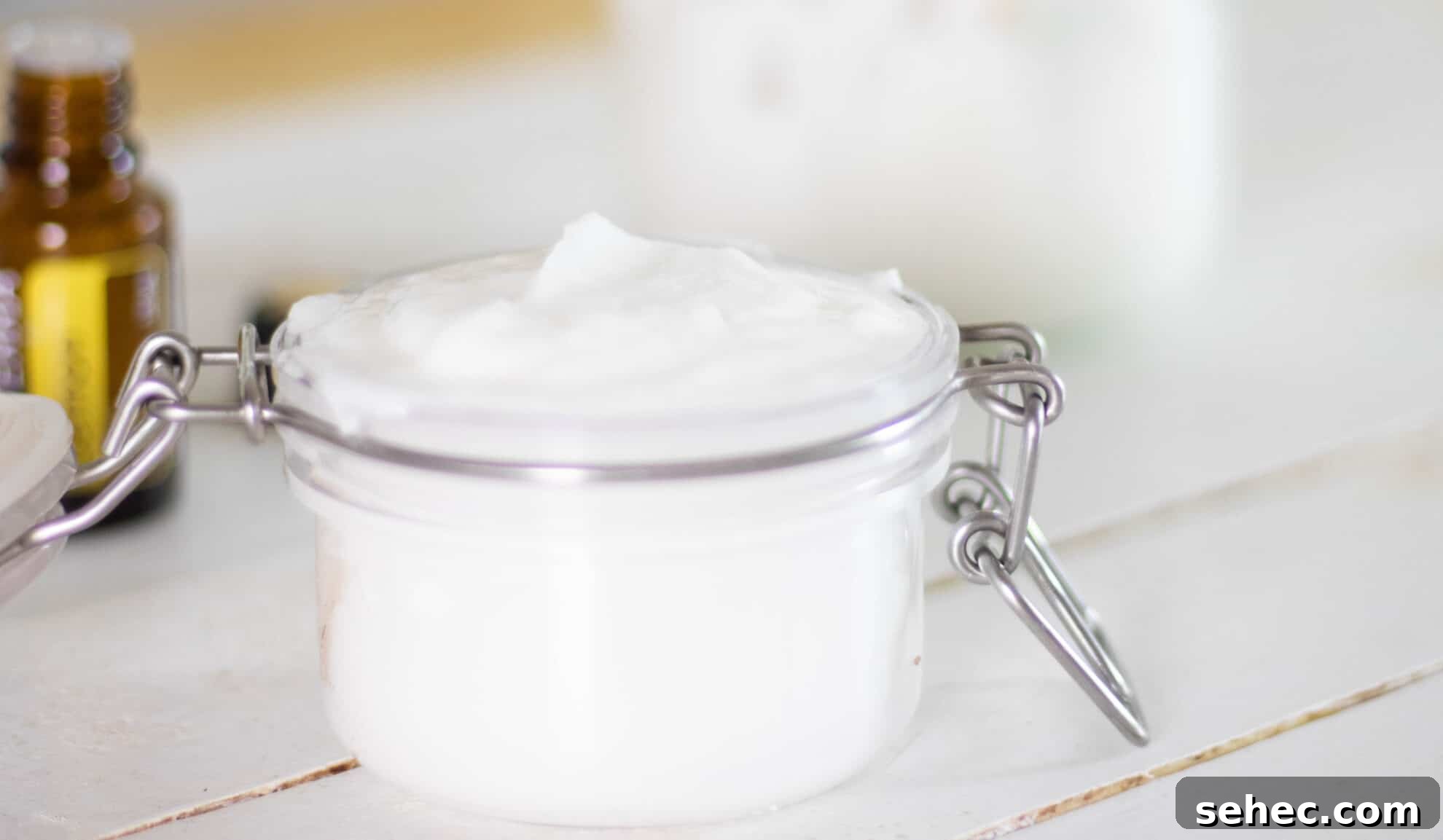 How to Clean Your Home with Natural Products 5 DIY shower cleaner in flip top glass mason jar on table with essential oil bottle in background.