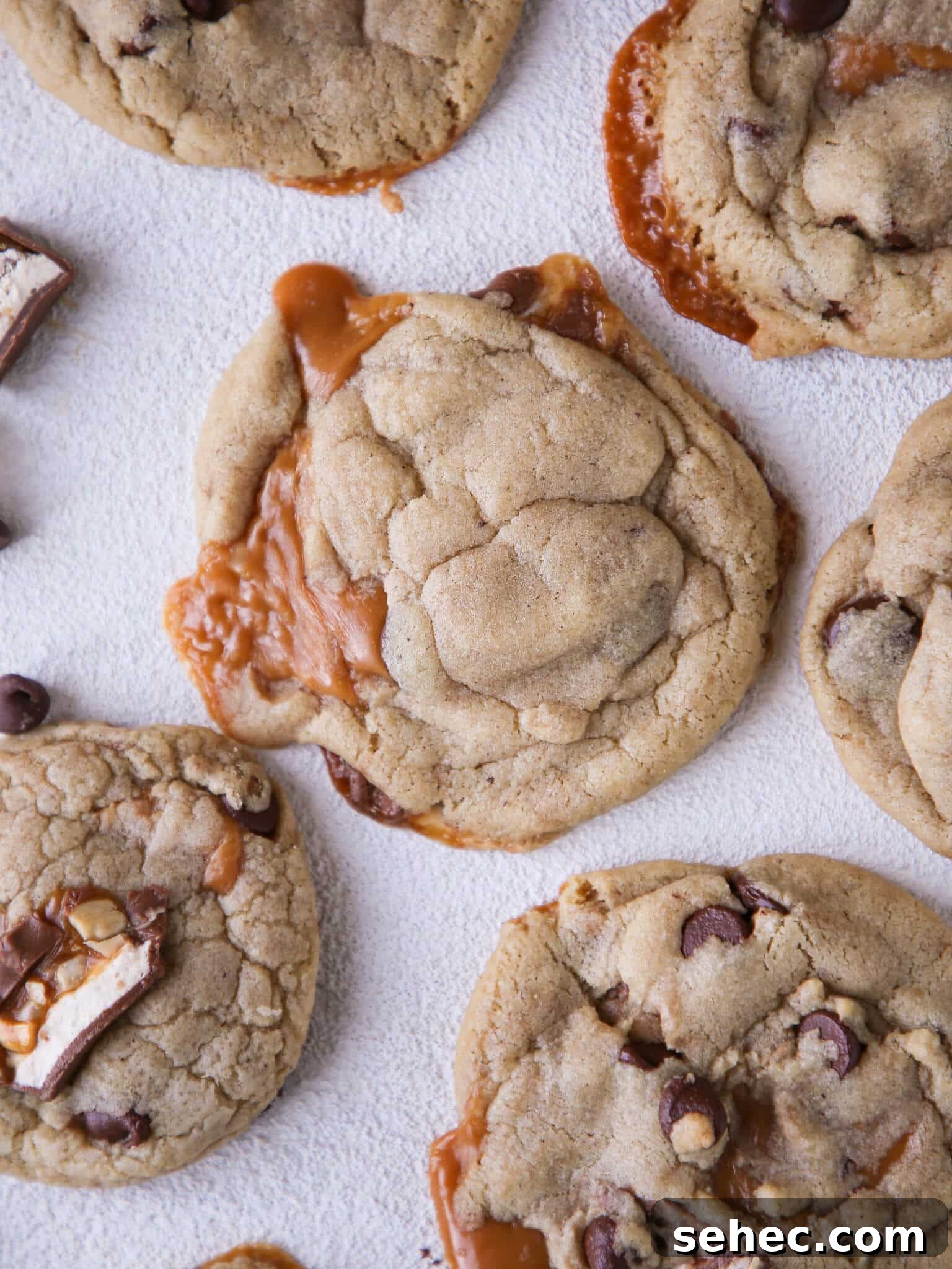 Brown Butter Snickers Cookies Stuffed With Caramel 5 Caramel Stuffed Brown Butter Snickers Chocolate Chip Cookies with caramel spilling out