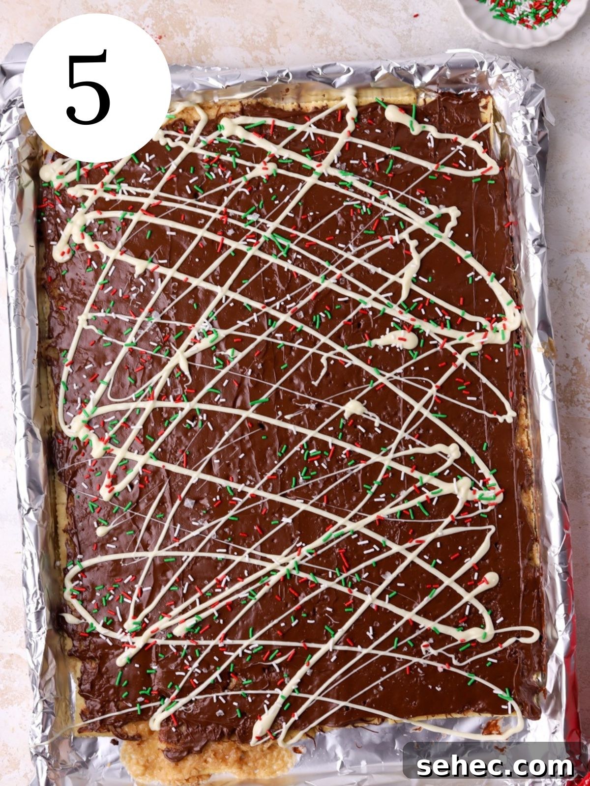 Christmas Crack Saltine Cracker Toffee Recipe 8 Christmas Crack topped with sprinkles on a baking sheet