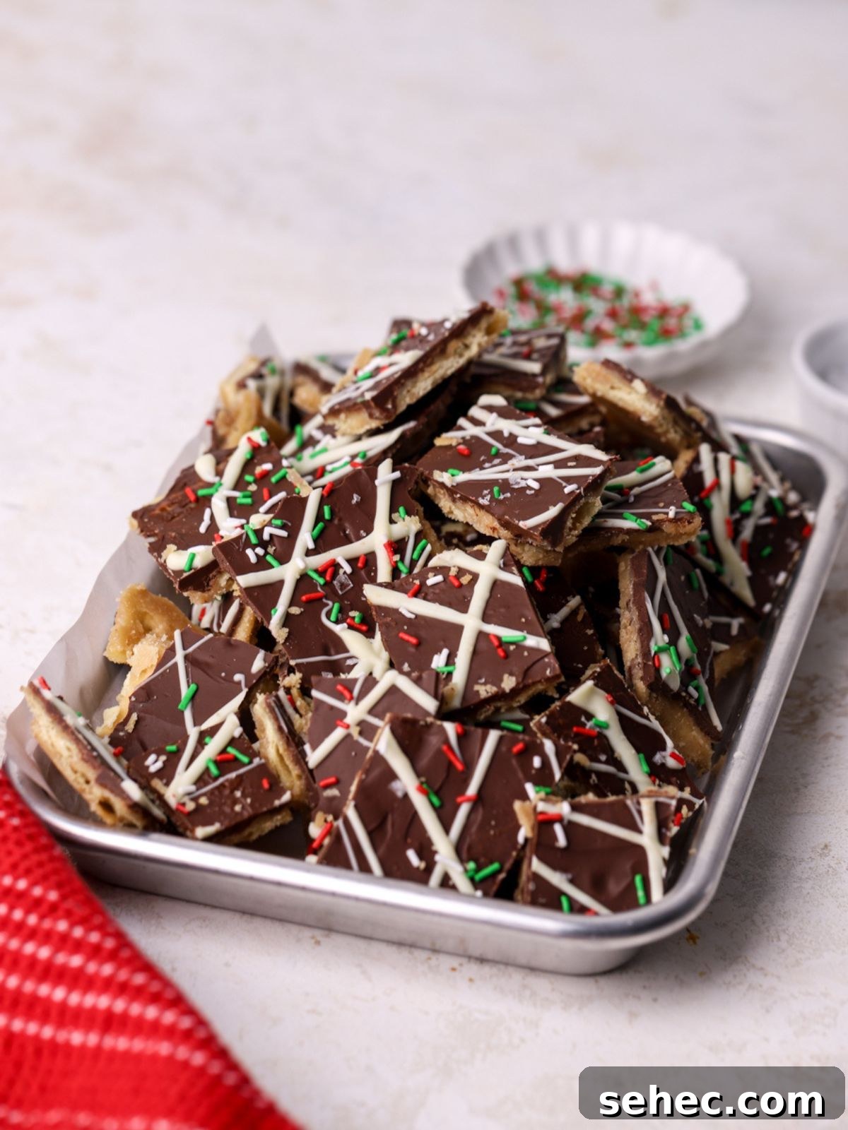 Christmas Crack Saltine Cracker Toffee Recipe 10 Christmas Crack with sprinkles on a small baking sheet