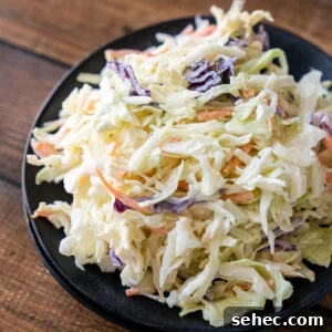 Creamy Coleslaw Recipe with Crunchy Cabbage and Carrots 5 Black plate filled with creamy Coleslaw recipe.