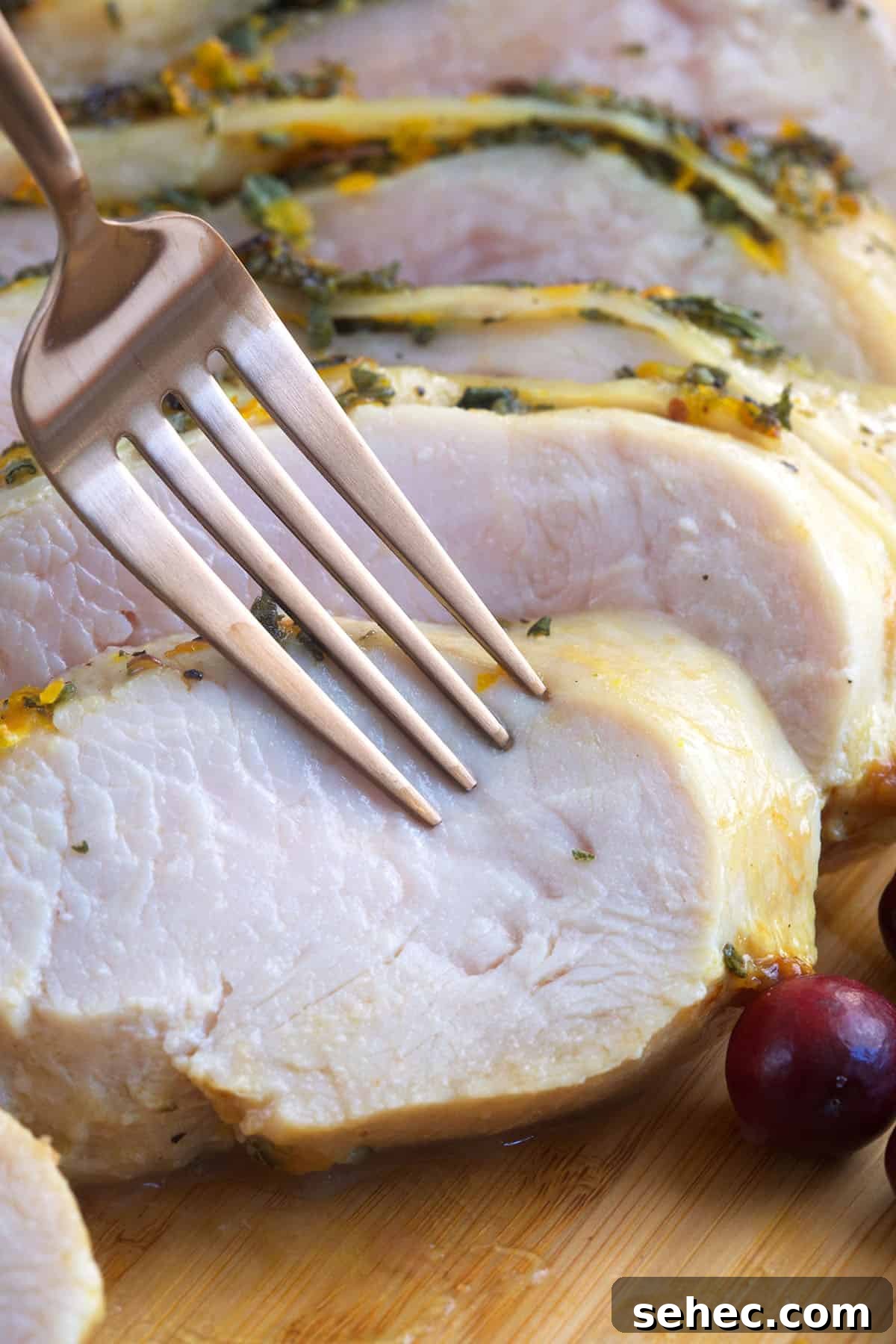 Roasted Turkey Breast with Honey Butter Glaze 4 A fork is piercing a piece of roasted turkey breast.