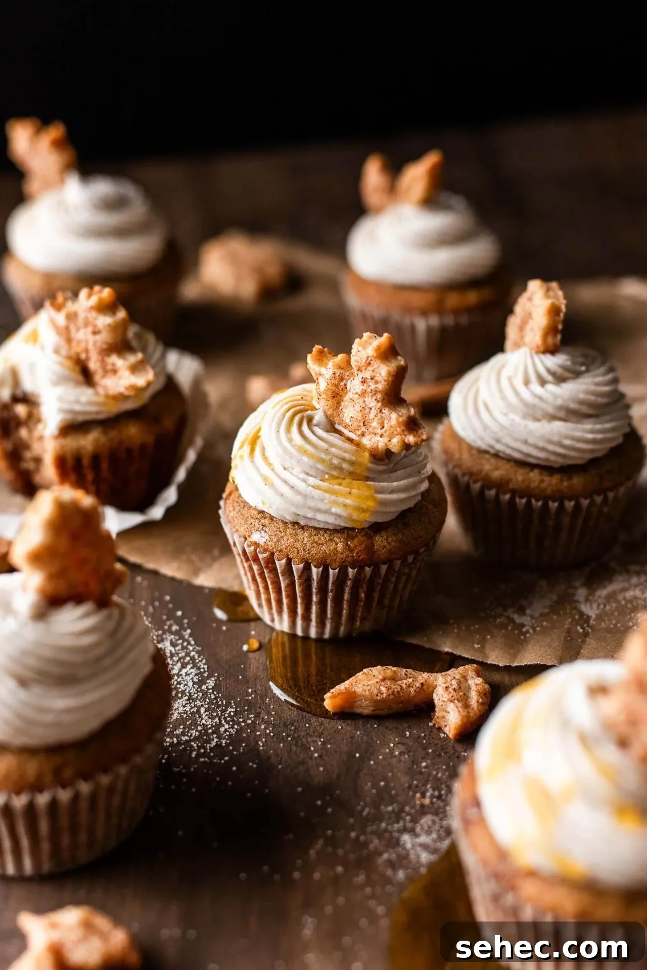 Maple Chai Spice Cupcakes 2 frosted maple cupcakes decorated with leaf shaped pie crust on tabletop