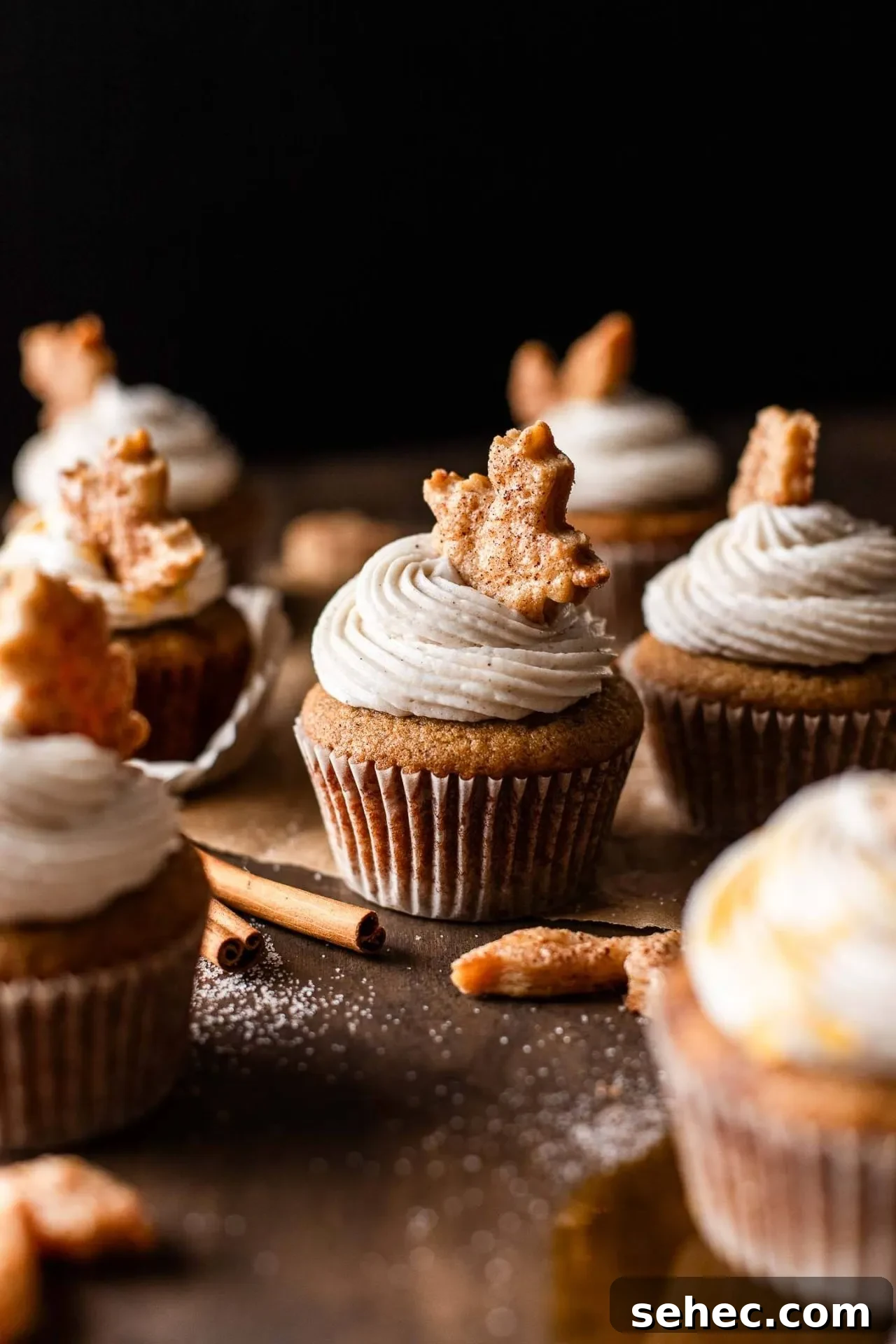 Maple Chai Spice Cupcakes 6 frosted maple cupcakes decorated with leaf shaped pie crust on tabletop