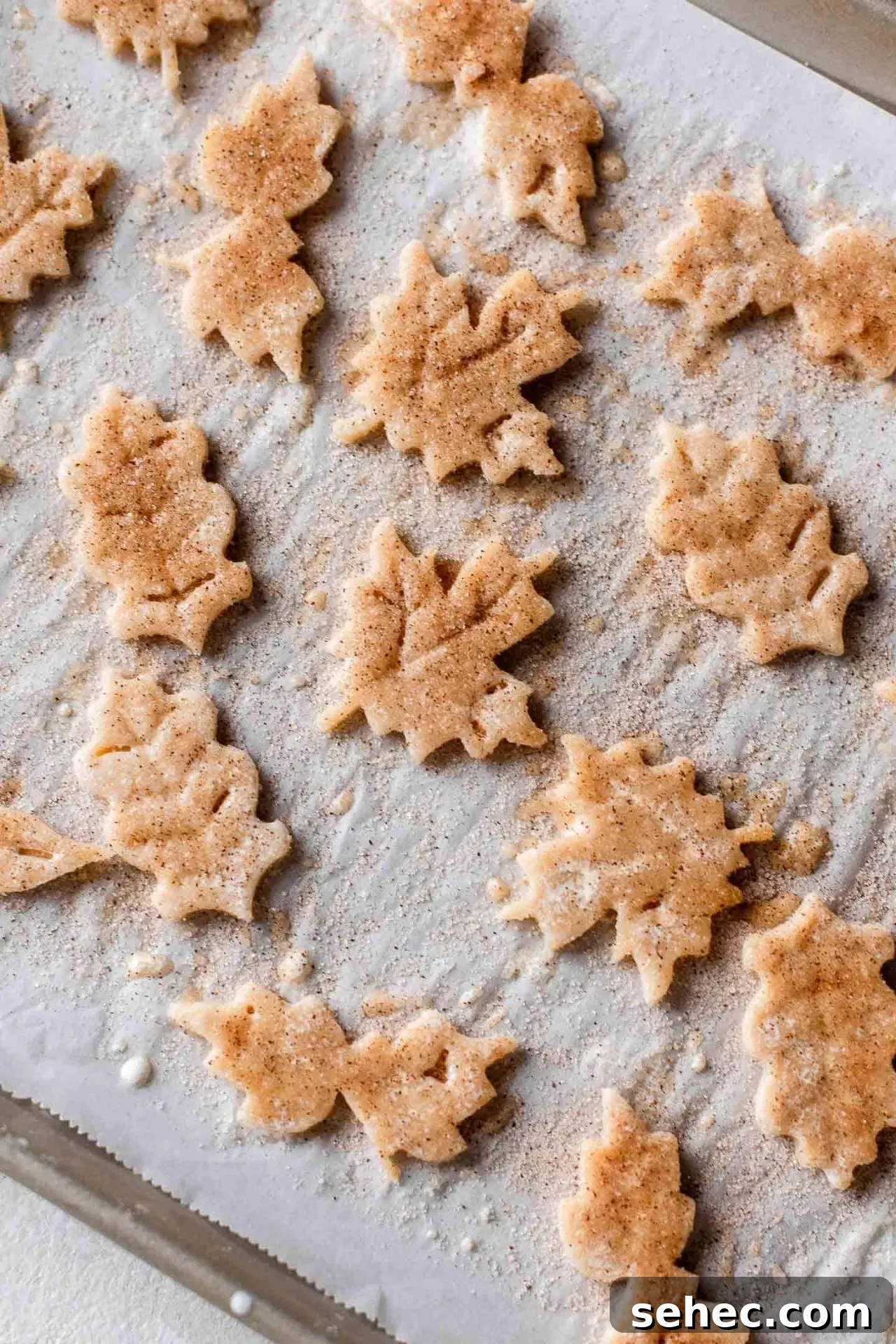Maple Chai Spice Cupcakes 8 maple cupcakes pie leaf decoration cutouts on parchment lined baking sheet topped with chai sugar