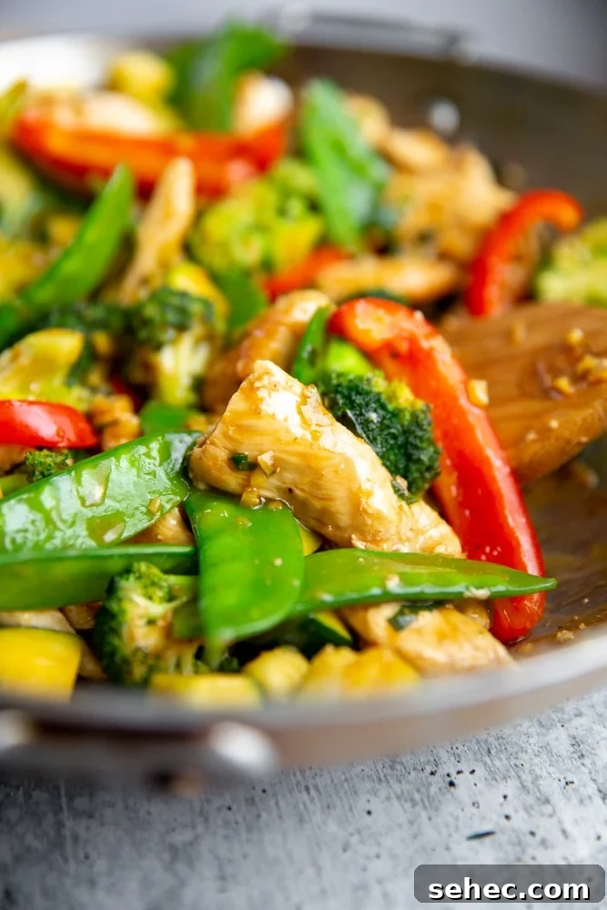 Stir Fry Recipe with Any Vegetables and Meat 2 Close up of a stir fry in a wok with a wooden spoon.