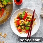 Stir Fry Recipe with Any Vegetables and Meat 14 Healthy stir fry in a bowl with chopsticks, with a wok alongside.