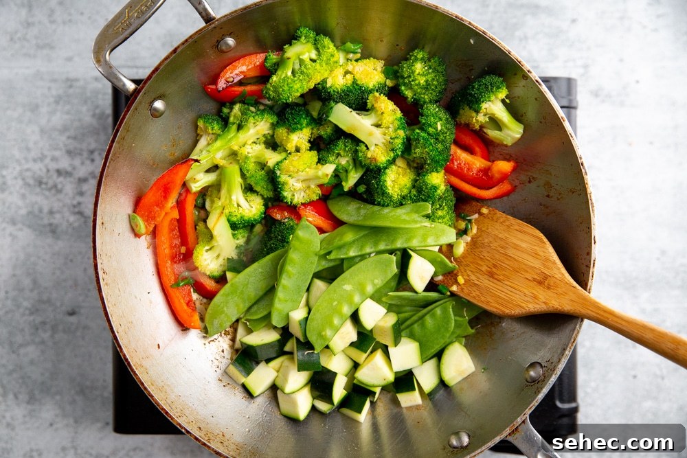 Stir Fry Recipe with Any Vegetables and Meat 8 Process shot showing tender vegetables going into a healthy stir fry in a work.