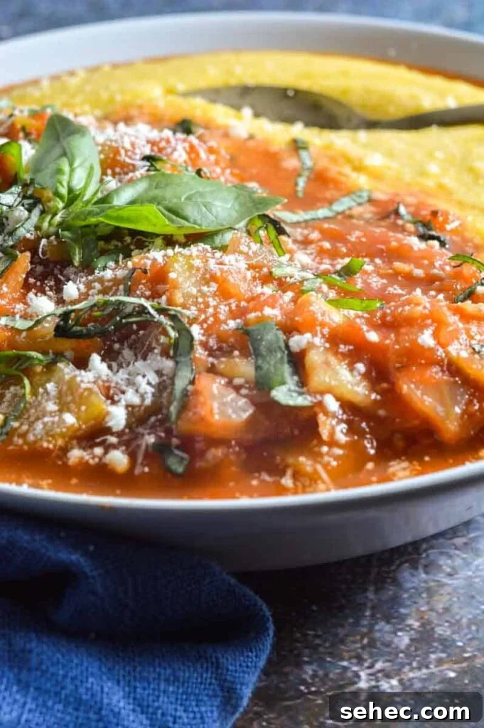 Zucchini Marinara Recipe 3 A close up of cooked zucchini marinara in a white bowl with a spoon