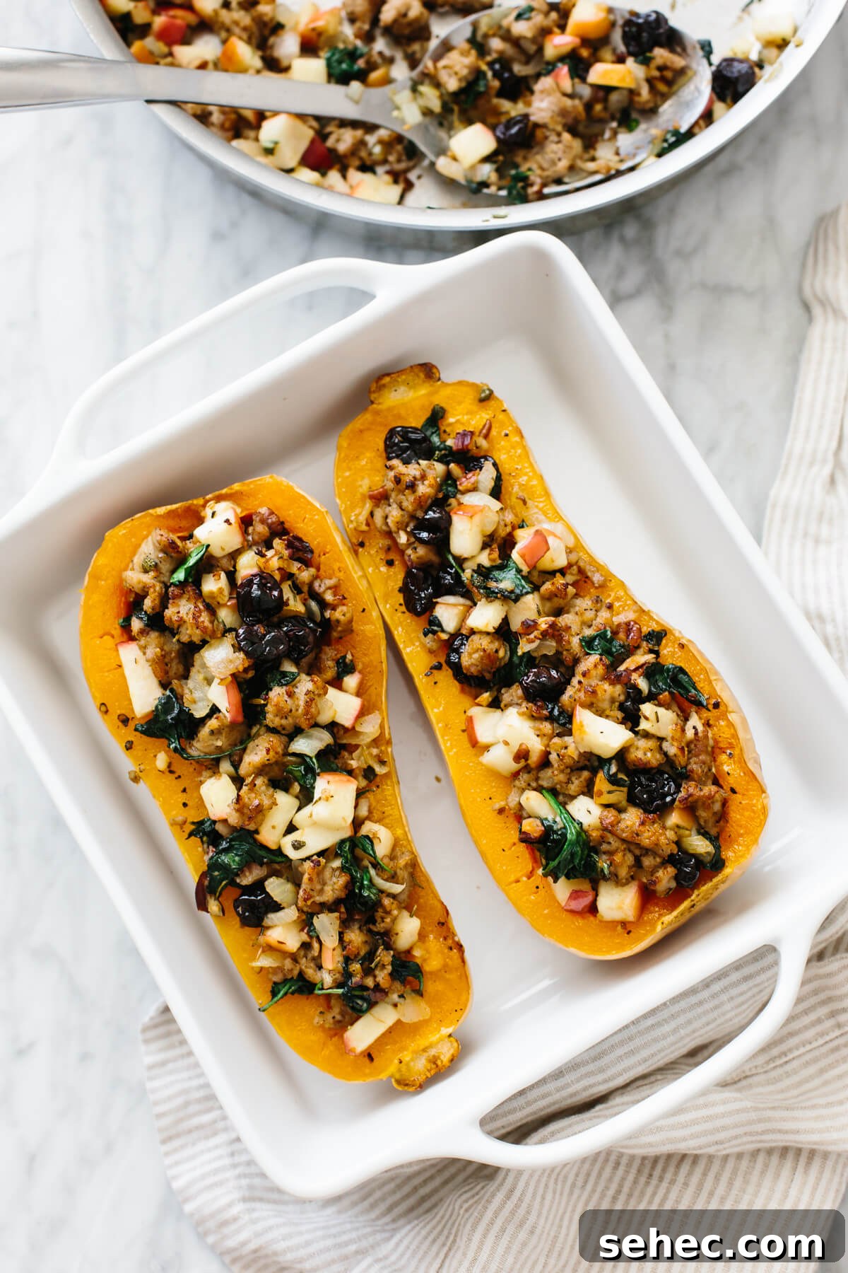 Butternut Squash Recipes for Soups, Sides, and Mains 5 Butternut squash filled with sausage apples and other ingredients in a baking dish.