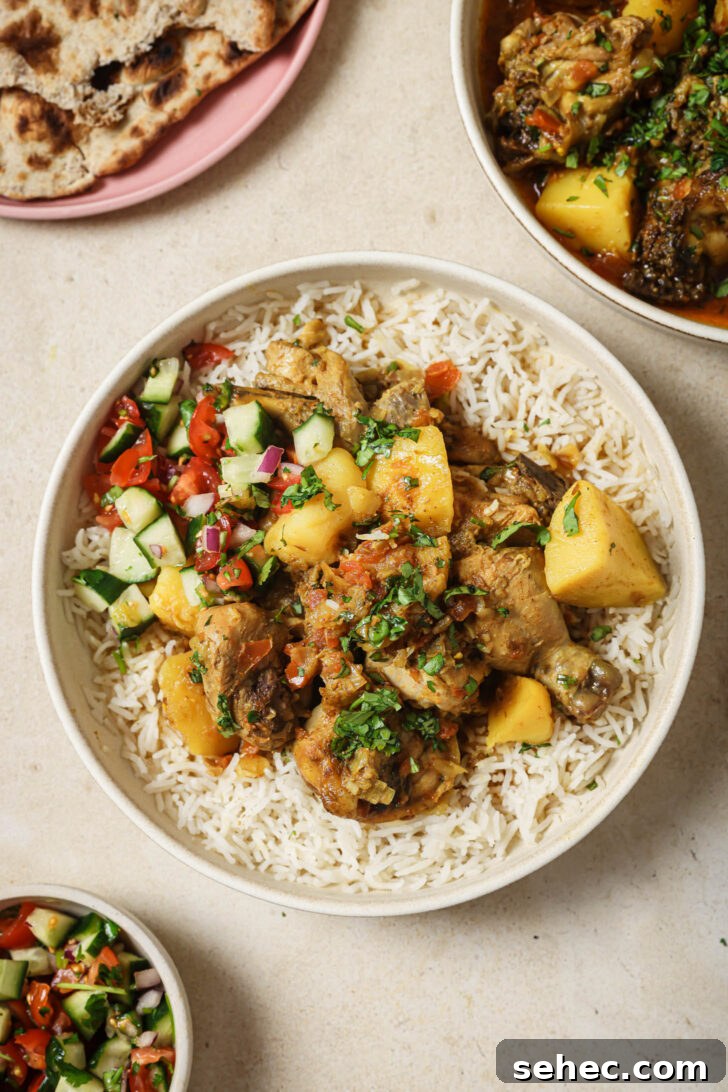 Instant Pot Chicken Curry Recipe 3 A bowl of rice topped with Pakistani Chicken Curry and Kachumber.