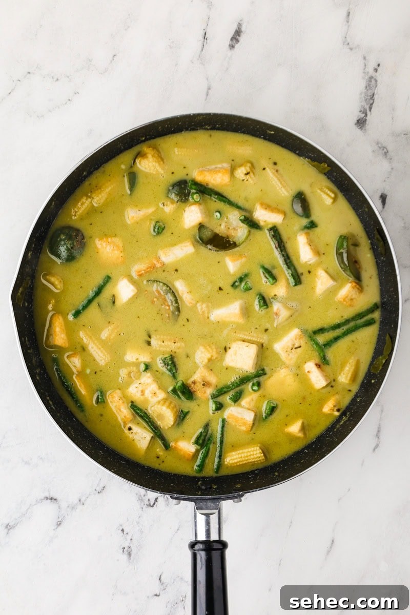 Thai Green Tofu Curry Recipe 11 Tofu, long beans, coconut sugar, and fish sauce added to finish Thai green curry in a pan.