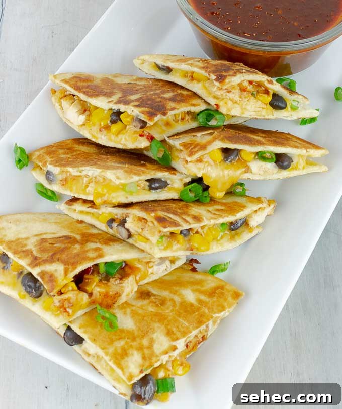 Chipotle BBQ Chicken Quesadillas 2 quartered Chipotle Barbecue Sauce Chicken Quesadillas on white platter